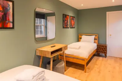 a room with two beds and a table and a mirror at Host & Stay - The Georgian Quarter at Catharine House in Liverpool
