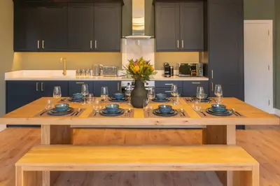 a kitchen with a wooden table with plates and glasses at Host & Stay - The Georgian Quarter at Catharine House in Liverpool