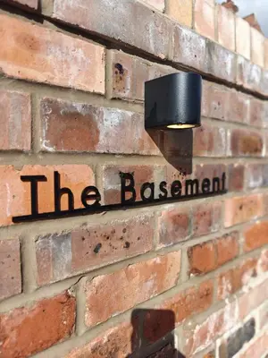 a sign on the side of a brick wall at The Basement in Saint Annes on the Sea