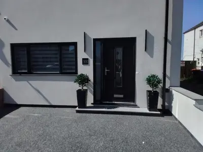 a house with a black door and two potted plants at Beachview apartment in Cleveleys
