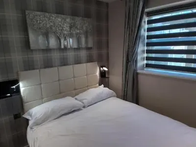 a bedroom with a white bed with a window at Beachview apartment in Cleveleys