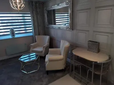 a living room with chairs and a table and a window at Beachview apartment in Cleveleys