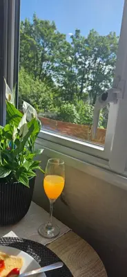 a glass of orange juice sitting on a table next to a window at Hideaway Ribble Valley in Preston