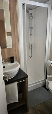 a bathroom with a white sink and a shower at Hideaway Ribble Valley in Preston