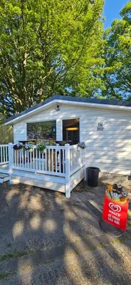 a white shed with a porch and a fence at Hideaway Ribble Valley in Preston
