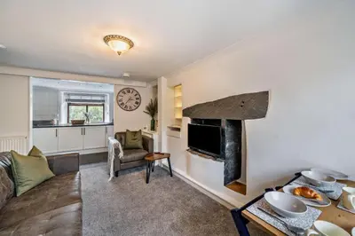 a living room with a couch and a fireplace at Quarter Deck in Ulverston