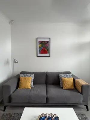 a living room with a gray couch with yellow pillows at Gertrude house in Saint Helens