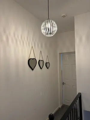 a hallway with three mirrors on a wall at Gertrude house in Saint Helens