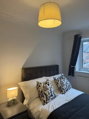 a bedroom with a bed with pillows and a lamp at Gertrude house in Saint Helens