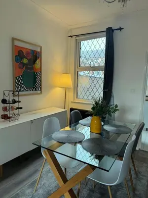 a dining room with a glass table and chairs at Gertrude house in Saint Helens
