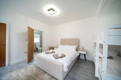 a bedroom with a white bed and a bunk bed at Spacious Duplex Apartment - Perfectly Situated in the Heart of the City in Blackpool