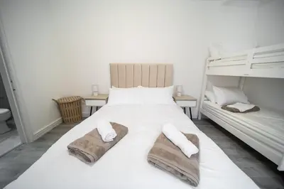 a bedroom with a white bed with towels on it at Spacious Duplex Apartment - Perfectly Situated in the Heart of the City in Blackpool