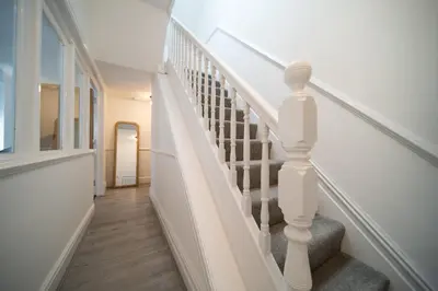 a staircase in a home with white railings at Spacious Duplex Apartment - Perfectly Situated in the Heart of the City in Blackpool