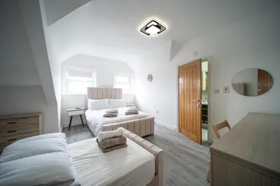 a bedroom with a bed and a couch and a table at Spacious Duplex Apartment - Perfectly Situated in the Heart of the City in Blackpool