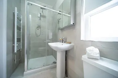a white bathroom with a sink and a shower at Spacious Duplex Apartment - Perfectly Situated in the Heart of the City in Blackpool