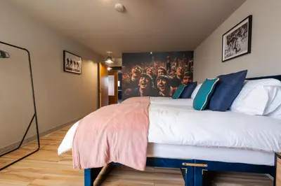 a bedroom with a large bed with a poster on the wall at City centre two bedroom apartment in the heart of Liverpool in Liverpool