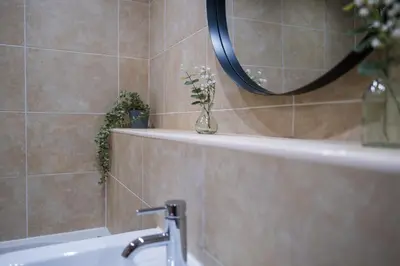 a bathroom with a sink and a vase with flowers in it at City centre two bedroom apartment in the heart of Liverpool in Liverpool