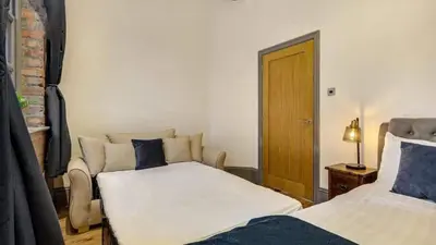 a room with two beds and a couch in it at Central Warehouse Apt - Sleeps 8, Pet Friendly in Liverpool