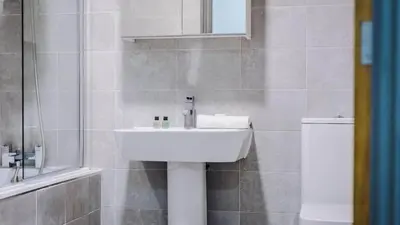 a bathroom with a sink and a toilet at Central Warehouse Apt - Sleeps 8, Pet Friendly in Liverpool