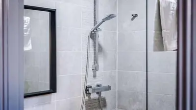 a bathroom with a shower with a glass door at Central Warehouse Apt - Sleeps 8, Pet Friendly in Liverpool
