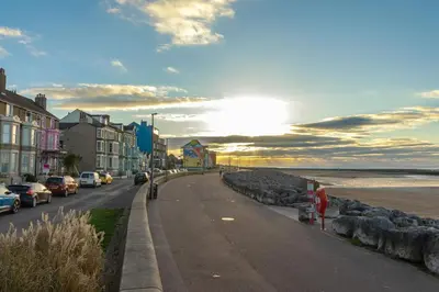 a street with cars parked on the side of a beach at Sunbeam House 1 Morecambe Pet Friendly in Morecambe