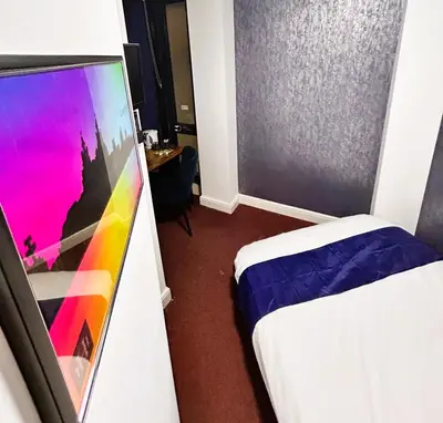 a hotel room with two beds and a tv at Hillcrest Liverpool City Central in Liverpool