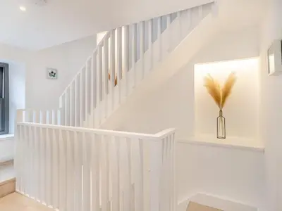 a white staircase in a home with a vase of feathers at Beach Haven in Arnside