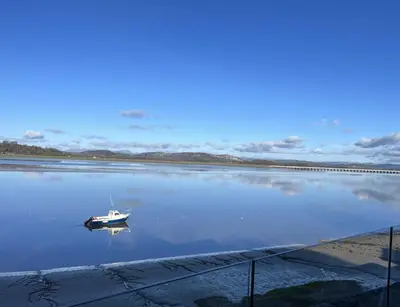 a boat sitting in the middle of a body of water at Beach Haven in Arnside