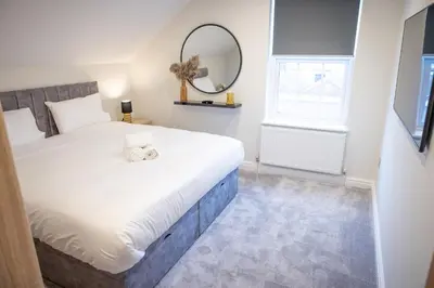 a bedroom with a large bed and a mirror at Lethbridge Villa 49 Apartment 3 Super Fibre WiFi, Free parking in Southport