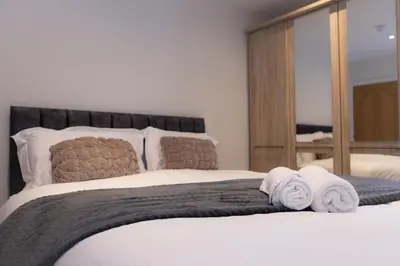 a bedroom with a large bed with towels on it at Lethbridge Villa 49 Apartment 2 Super Fibre WiFi, free parking in Southport