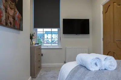 a bedroom with a bed and a television on the wall at Lethbridge Villa 49 Apartment 2 Super Fibre WiFi, free parking in Southport