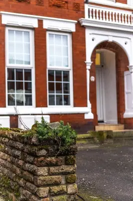 a brick house with a stone wall in front of it at Lethbridge Villa 49 Apartment 2 Super Fibre WiFi, free parking in Southport