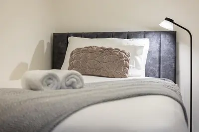 a bedroom with a bed with a pillow and a lamp at Lethbridge Villa 49 Apartment 2 Super Fibre WiFi, free parking in Southport
