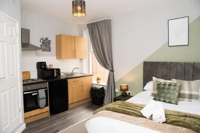 a small bedroom with a bed and a kitchen at Vance Retreat in Blackpool