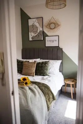a bedroom with a bed with a green accent wall at Vance Retreat in Blackpool
