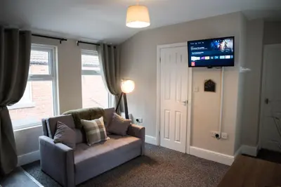a living room with a couch and a flat screen tv at Vance Retreat in Blackpool