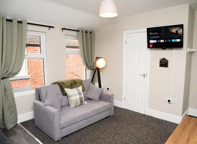 a living room with a gray couch and a window at Vance Retreat in Blackpool