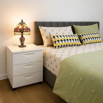 a bedroom with a bed and a nightstand with a lamp at Prime Comfort Wigan in Ince-in-Makerfield