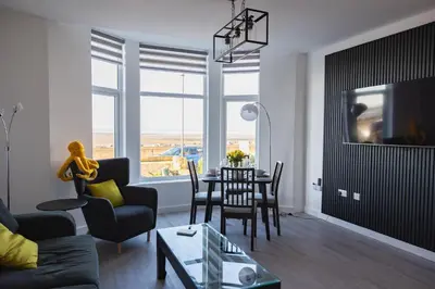 a living room with a table and chairs at Sunbeam House 2 Morecambe Accessible in Morecambe