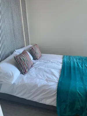 a white bed with two pillows on top of it at Sunbeam House 2 Morecambe Accessible in Morecambe