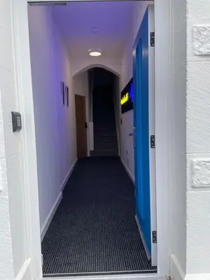 a hallway with purple walls and a hallway with a blue door at Sunbeam House 2 Morecambe Accessible in Morecambe