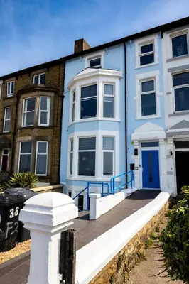 a blue and white house with a blue door at Sunbeam House 2 Morecambe Accessible in Morecambe