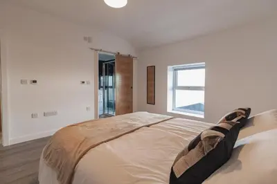 a white bedroom with a large bed with a window at Sunbeam House 3 Morecambe in Morecambe
