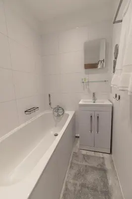 a white bathroom with a tub and a sink at Sunbeam House 3 Morecambe in Morecambe