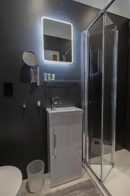 a bathroom with a shower and a sink and a mirror at Sunbeam House 3 Morecambe in Morecambe
