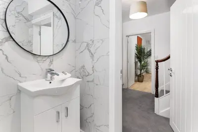 a bathroom with a sink and a mirror on the wall at Flatzy - City Centre Mansion, Sleeps 20, 5 Baths in Liverpool