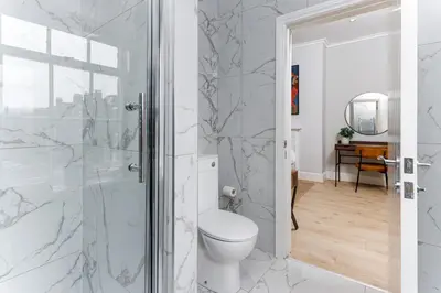 a bathroom with a toilet and a shower at Flatzy - City Centre Mansion, Sleeps 20, 5 Baths in Liverpool