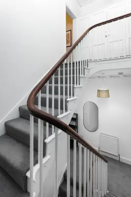 a staircase in a house with white walls at Flatzy - City Centre Mansion, Sleeps 20, 5 Baths in Liverpool