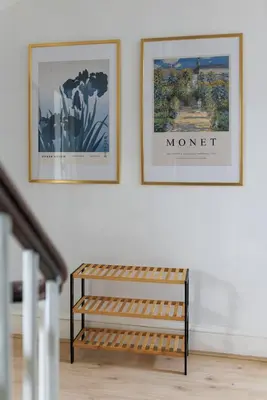 two framed pictures on a wall above a bench at Flatzy - City Centre Mansion, Sleeps 20, 5 Baths in Liverpool