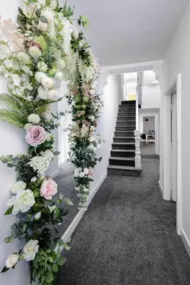 a hallway with a bunch of flowers on the wall at Blackpool Abode - Shaw Heights in Blackpool